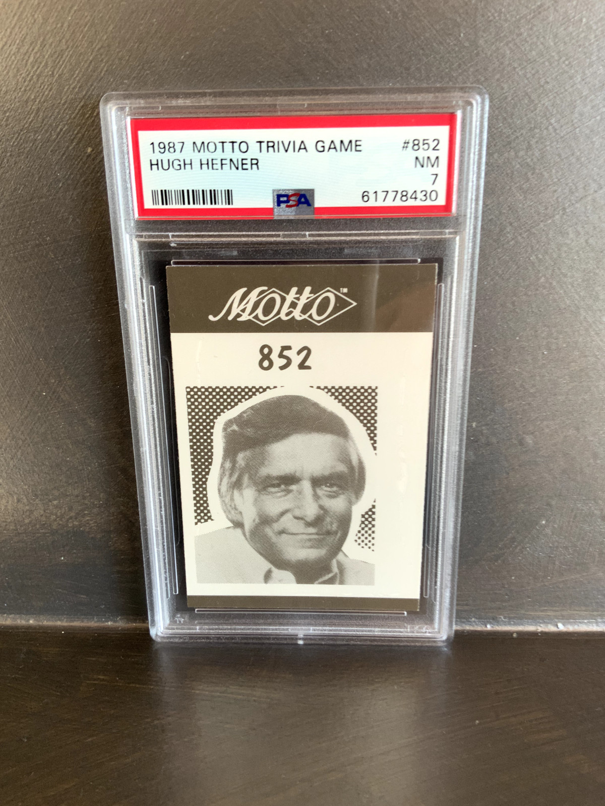 1987 Motto Trivia Game Hugh Hefner Rookie PSA 7 - POP ONE / NONE HIGHER.